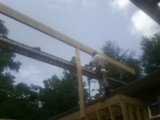 Carpenter setting a ridge beam over a new addition frame — Ice Dam Removal by Roofing Brothers in Manhasset