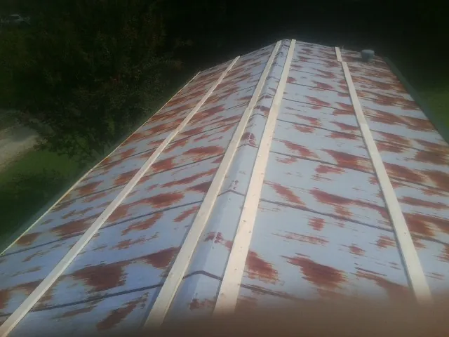 Rusted metal roof panels with new wood purlins before replacement — Storm Damage Roof Repair in Manhasset by Roofing Brothers