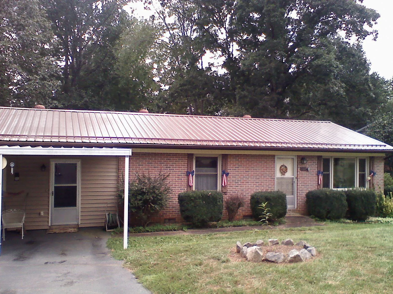 Bronze metal roof and carport on a brick ranch home — Roof Repair work by our crew in Manhasset